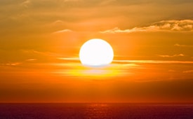getting out of a sales slump is like this picture of the sun rising over the ocean and the sky is yellow