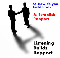 A darkened image of two men shaking hands and the slogan says "Listening builds rapport".