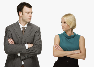 a man and women standing side by side with their arms crossed and they are looking at each other. They are certainly not building rapport in sales.